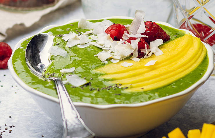 green smoothie bowl with mango and shredded coconut