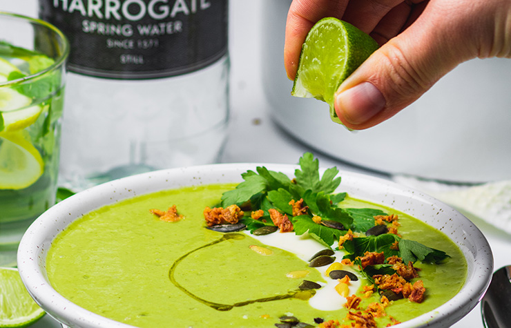 squeezing lime over vegan broccoli curry soup 