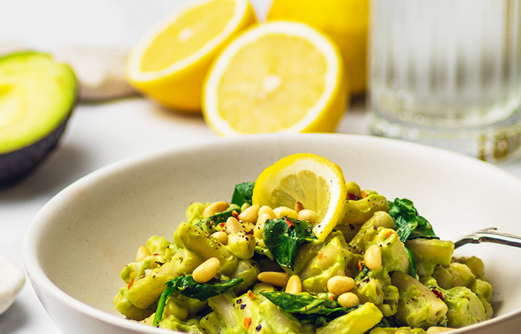 Delicious vegan recipe avocado pasta in bowl with lemon 